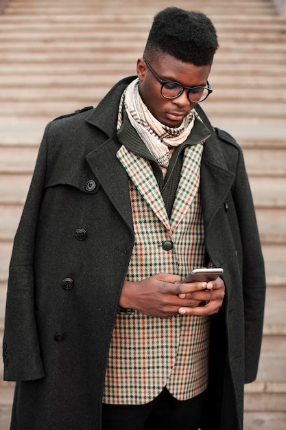 Free photo portrait of stylish young male texting on his phone