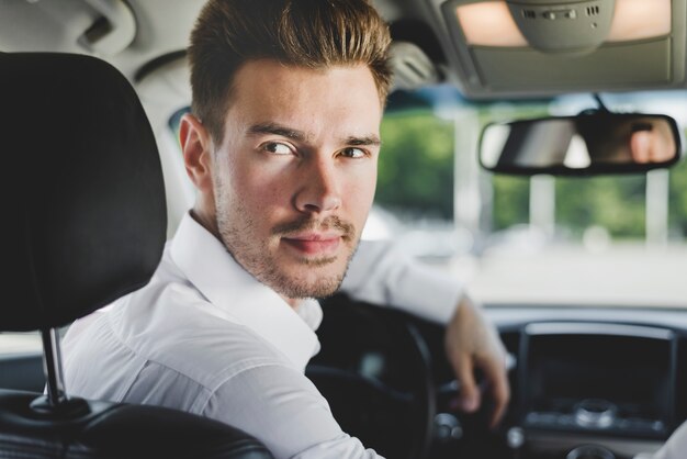 Портрет стильный молодой человек в машине