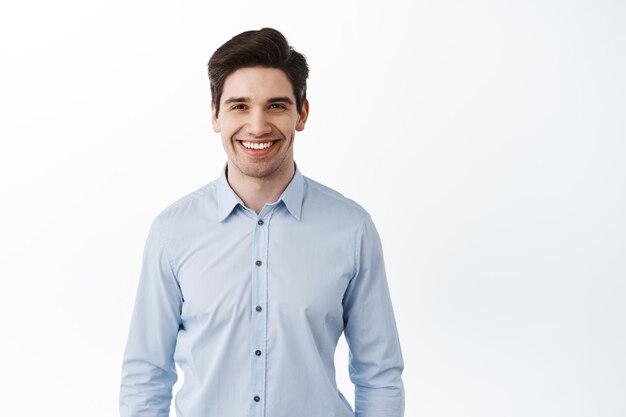 成功した実業家の肖像画、幸せなサラリーマンceo笑顔、ブルーカラーのシャツで白い背景に立って