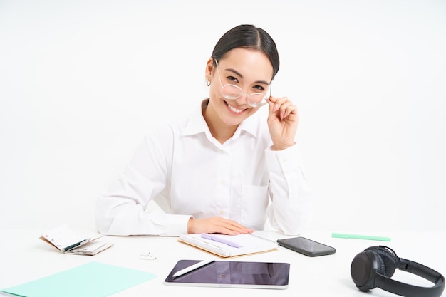 Free photo portrait of successful businesswoman office manager at workplace sits with digital tablet and her wo