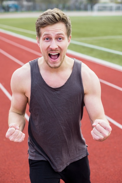 Portrait of successful male jogger with clenched fist