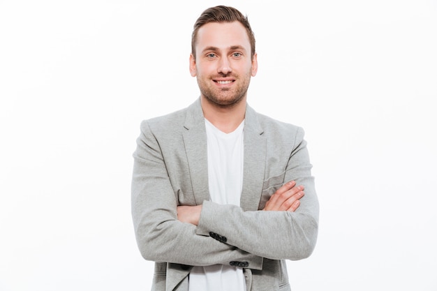 Free photo portrait of successful man having stubble posing with broad smile keeping arms folded