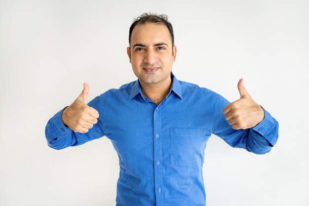 Portrait of successful mid adult businessman showing thumbs up