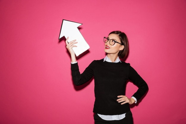 Free photo portrait of a successful young businesswoman with arrow pointing up