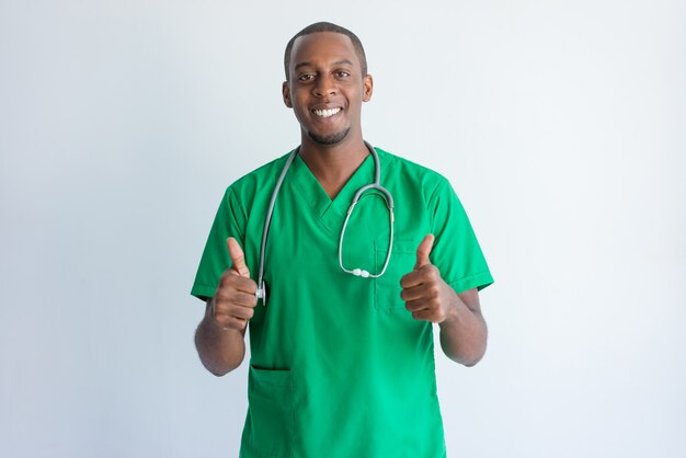 Portrait of successful young doctor showing thumbs up. 