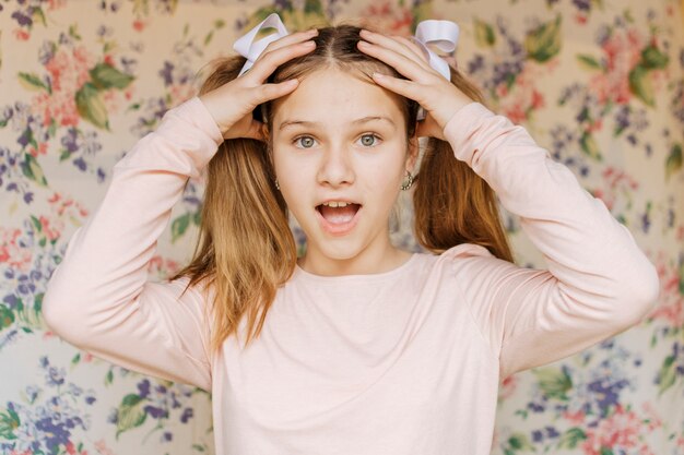 Portrait of a surprised girl with hand on head