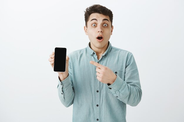 Portrait of surprised impressed handsome guy in casual clothes