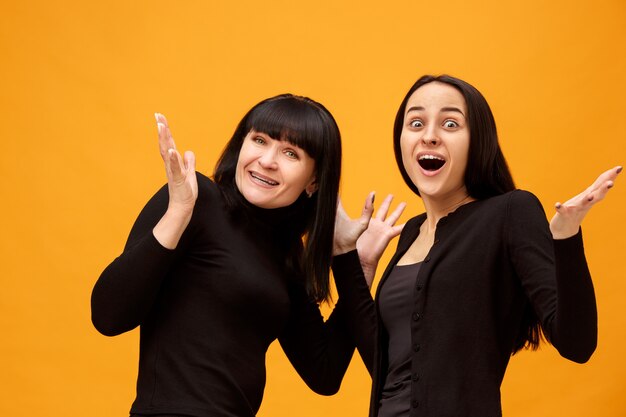 A portrait of a surprised mother and daughter at studio on gold