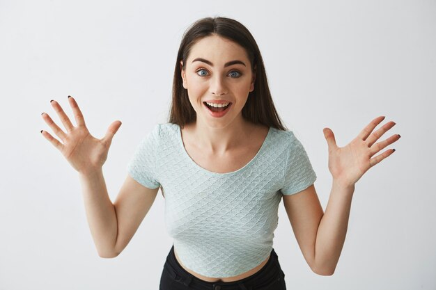 Portrait of surprised young beautiful girl with opened mouth smiling .