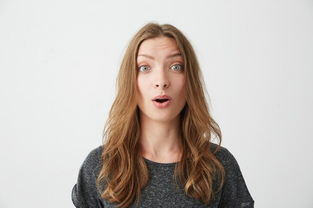Portrait of surprised young beautiful girl with opened mouth .