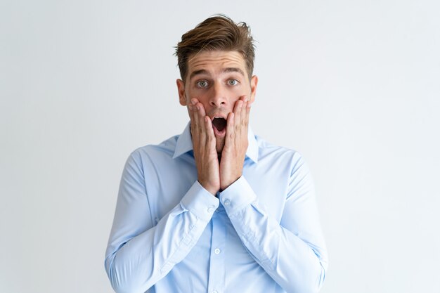 Portrait of surprised young businessman looking at camera