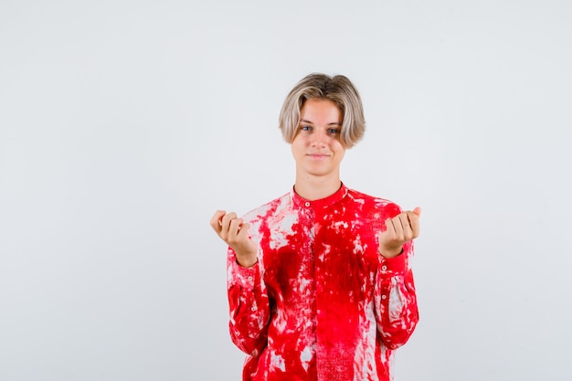 Portrait of teen blonde male spreading palms in clueless gesture in oversize shirt and looking confident front view