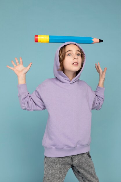彼の頭に大きな鉛筆で運ぶ十代の少年の肖像画