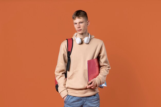 Portrait of a teen boy holding his backpack and his folder