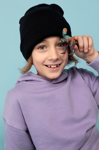 Portrait of teen boy playing with a dinosaur