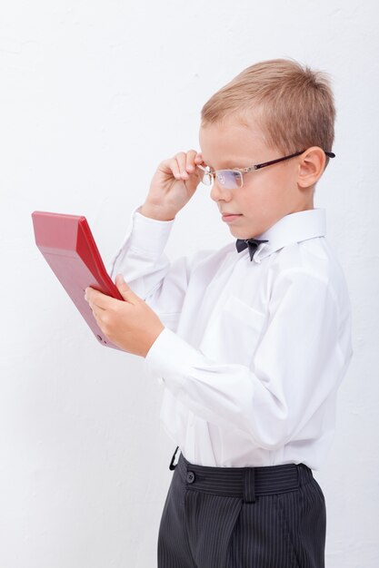 Portrait of teen boy with calculator on white background