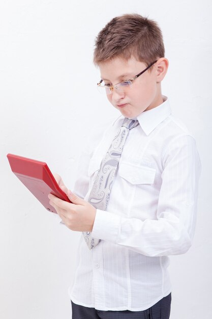 Portrait of teen boy with calculator over white background