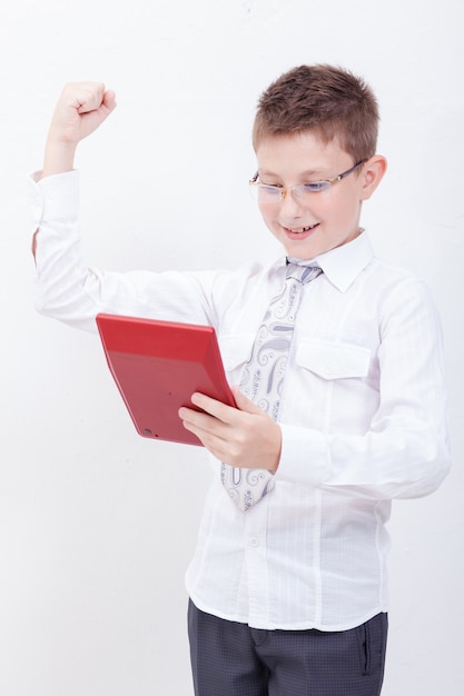 Portrait of teen boy with calculator on white wall