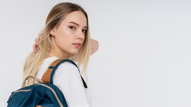 Portrait of a teen girl holding her backpack and her hair pulled back