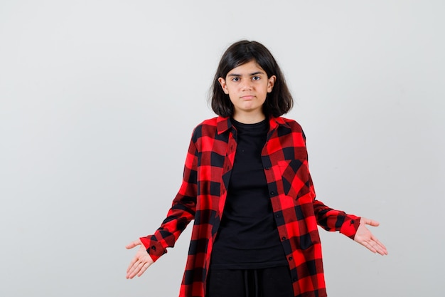 Portrait of teen girl showing helpless gesture in casual shirt and looking puzzled front view