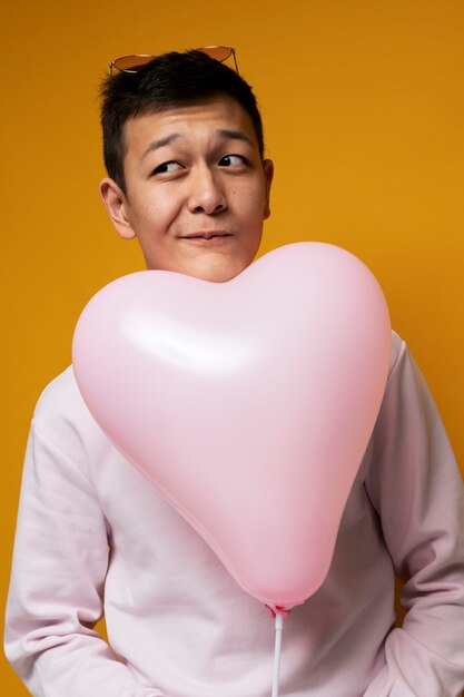 Портрет мальчика-подростка, держащего воздушный шар в форме сердца