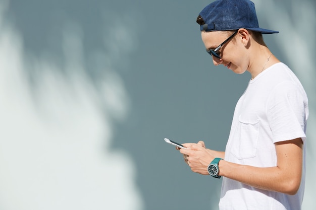 Free photo portrait of teenage boy with sunglasses and cap