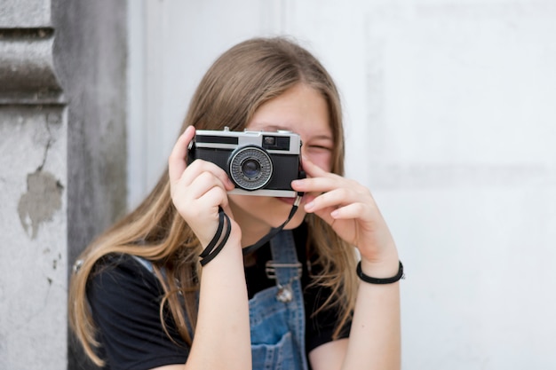 카메라로 그녀의 얼굴을 덮고 십대 여성 사진 작가의 초상