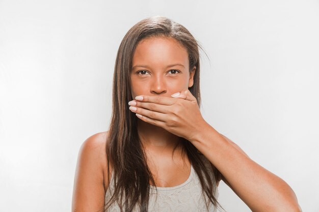 Portrait of a teenage girl covering her mouth
