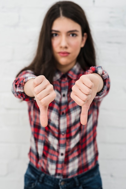 Portrait of teenage girl doing thumbs down