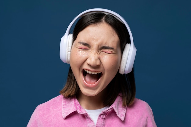 Free photo portrait of a teenage girl listening to music  and screaming