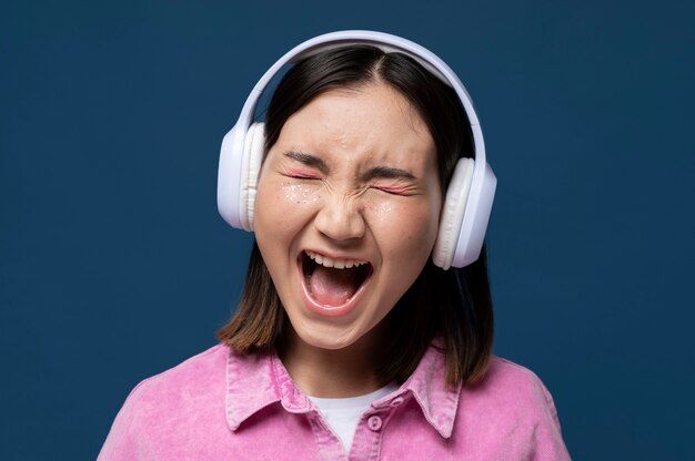 Portrait of a teenage girl listening to music  and screaming