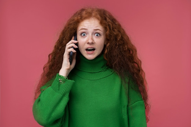 Портрет девочки-подростка, выглядящей удивленной во время разговора по телефону