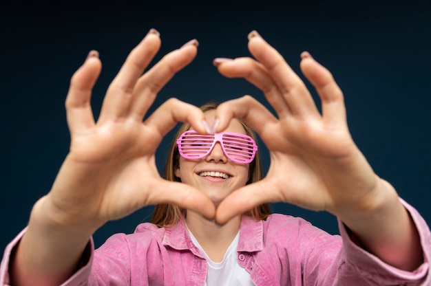 Ritratto di un'adolescente che mostra un cuore usando le mani