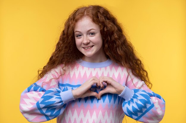 Portrait of teenage girl showing a heart with her hands