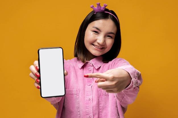 彼女のスマートフォンを見せて、それを指している10代の少女の肖像画