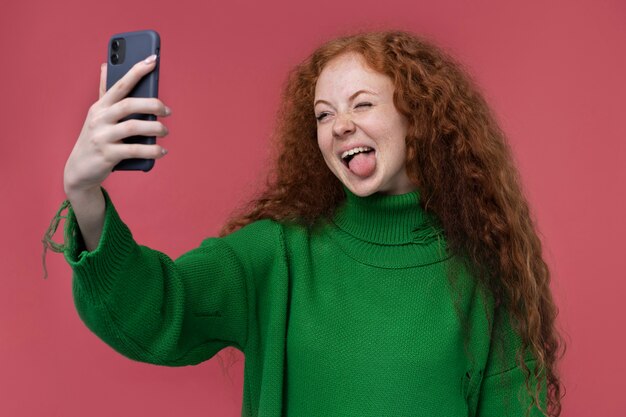 Portrait of teenage girl taking a selfie and sticking her tongue out