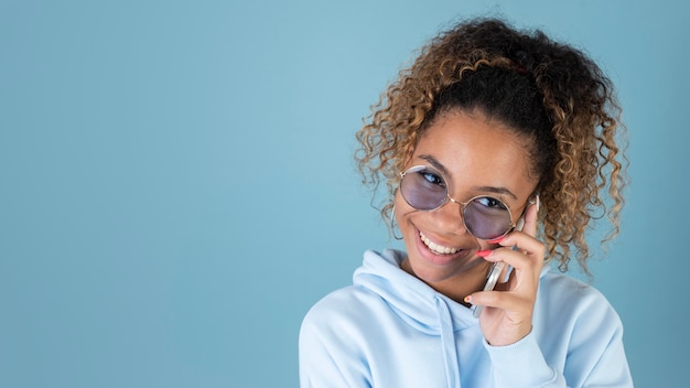 Foto gratuita ritratto di ragazza adolescente che indossa occhiali da sole e utilizza smartphone