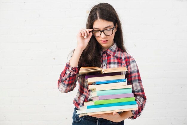 Portrait of teenage girl with stack of books