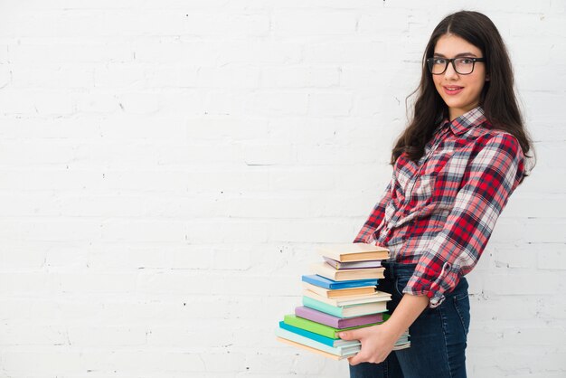 Portrait of teenage girl with stack of books