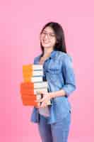 Free photo portrait teenage pretty girl holding stack of books and smiley on pink, education teenge concept