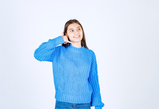 Portrait of teenager girl in blue sweater standing and calling someone.