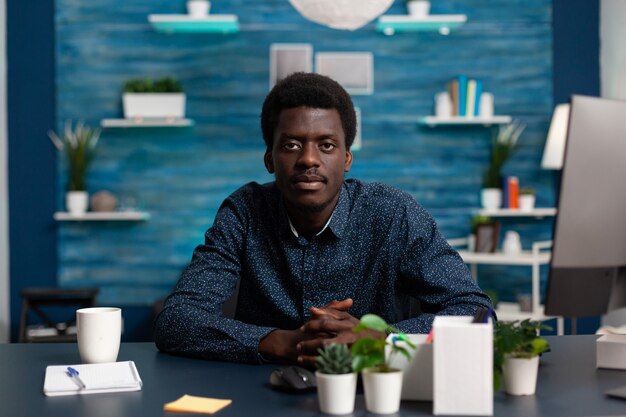 Portrait of teenager sitting at desk table in living room