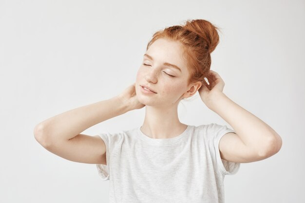 Portrait of tender redhead woman smiling with closed eyes.