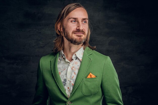 Portrait of thoughtful man with long hair and retro style at dark photo studio.