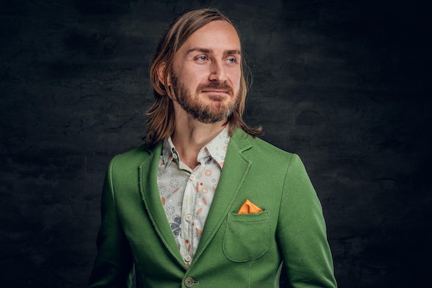 Portrait of thoughtful man with long hair and retro style at dark photo studio.