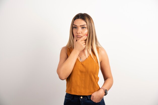 Portrait of thoughtful young woman posing on white background.