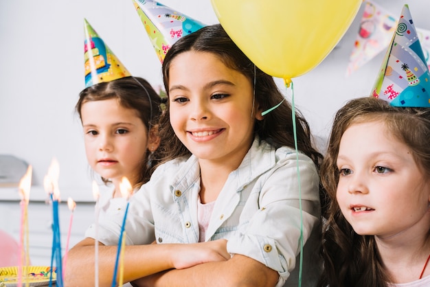 Foto gratuita ritratto di tre ragazze guardando candele colorate