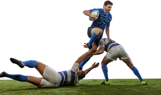 Foto gratuita ritratto di tre uomini giocatori di rugby che giocano a calcio sul campo in erba isolato su sfondo bianco