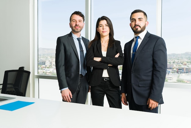 Portrait of three professional lawyers in suits making eye contact. Busy businessmen and female boss working together to make collaborative teamwork