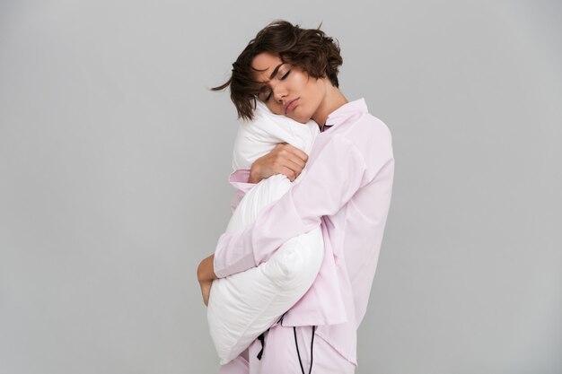 Портрет усталой женщины в пижаме с подушкой